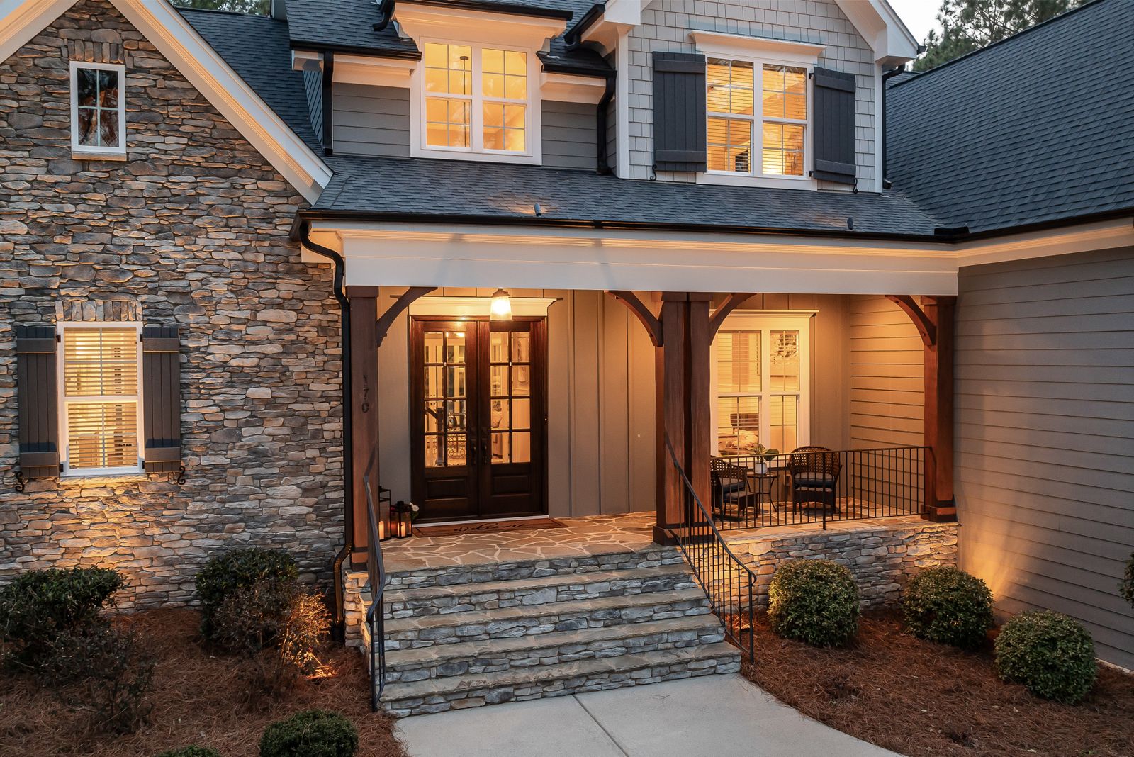 A charming craftsman home with a welcoming front porch at dusk
